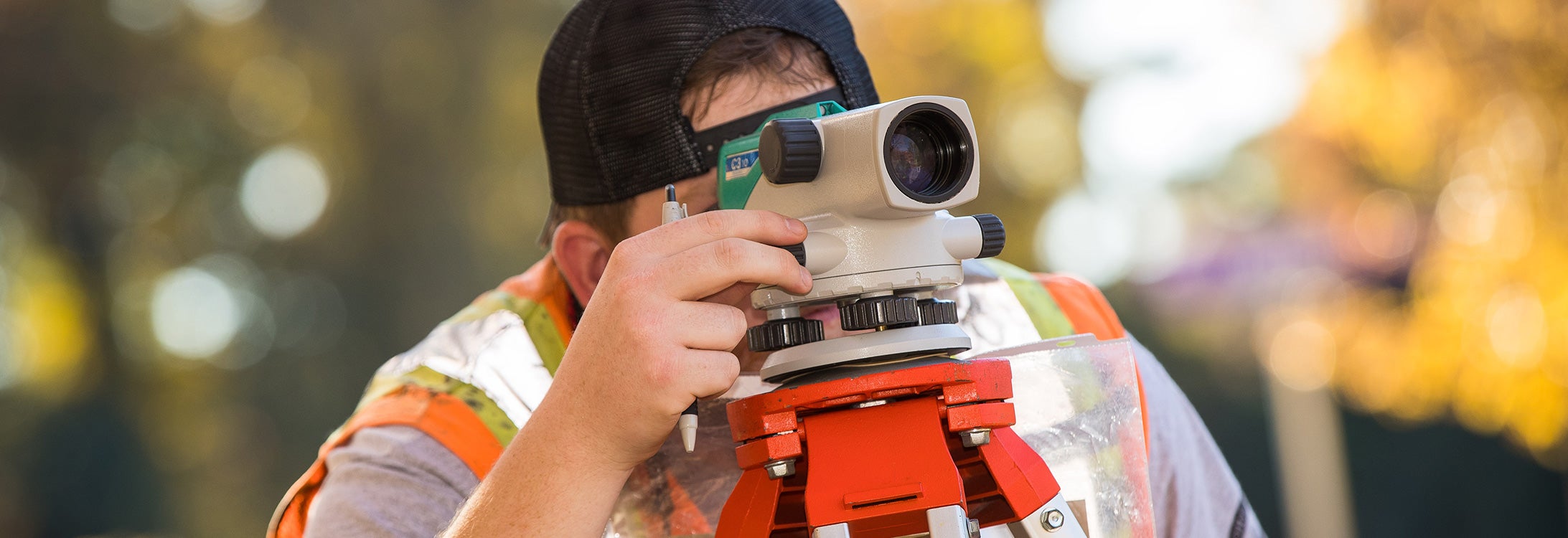A man surveys the landscape through a scope.